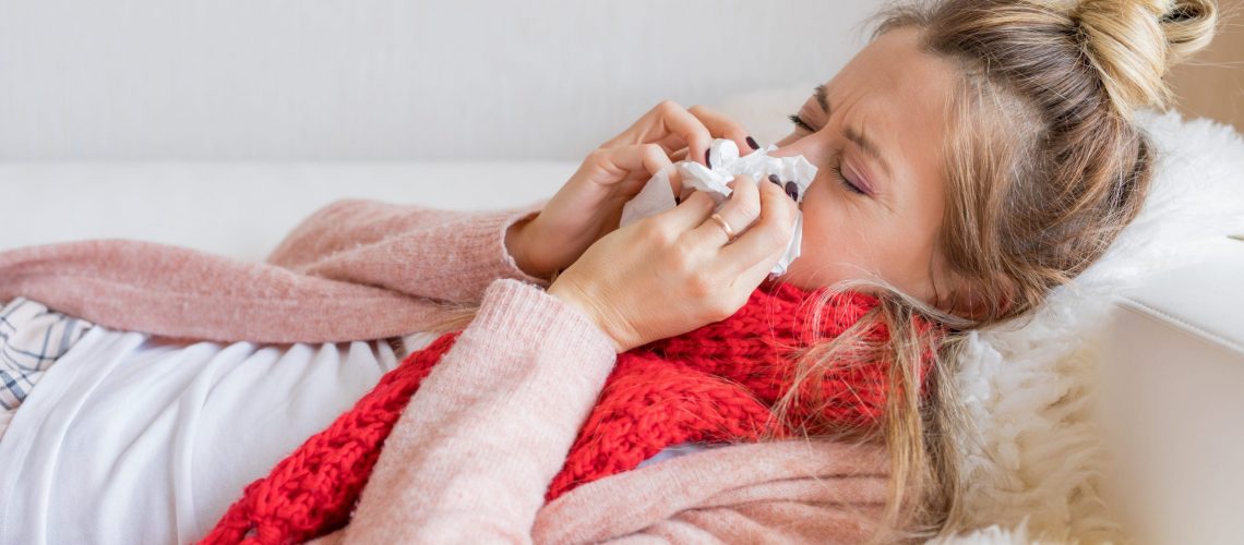 Sick woman with tissue and running nose