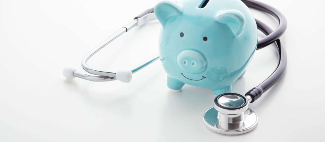 Piggy bank with stethoscope on white table, health saving account, hsa concept