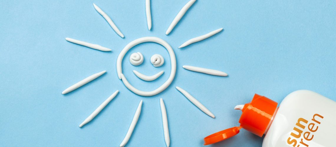 Sunscreen. Cream in the form of sun on blue background with white tube.