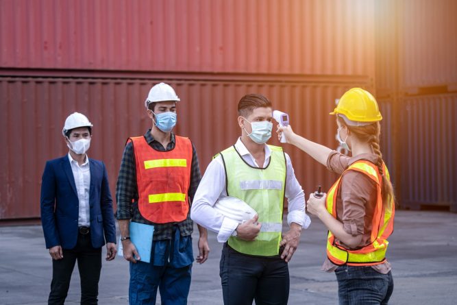 Virus Covid 19 crisis Staff check fever by digital thermometer visitor before entering the work for scan and protect from Coronavirus or COVID-19, Engineer and factory concept at container yard