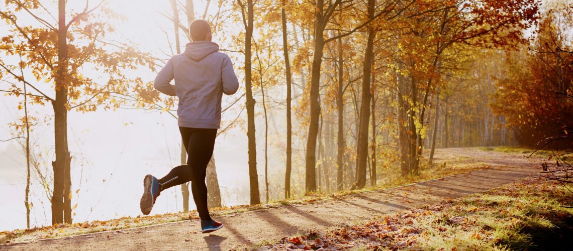 Man running in park at autumn morning. Healthy lifestyle concept