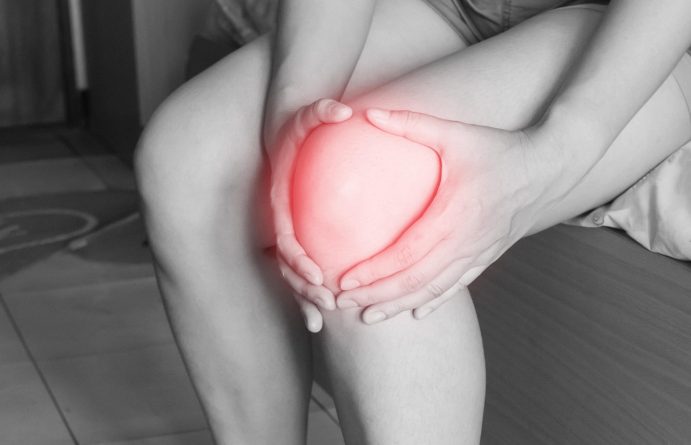 Person holding knee in pain showing muscle discomfort possibly caused by dehydration